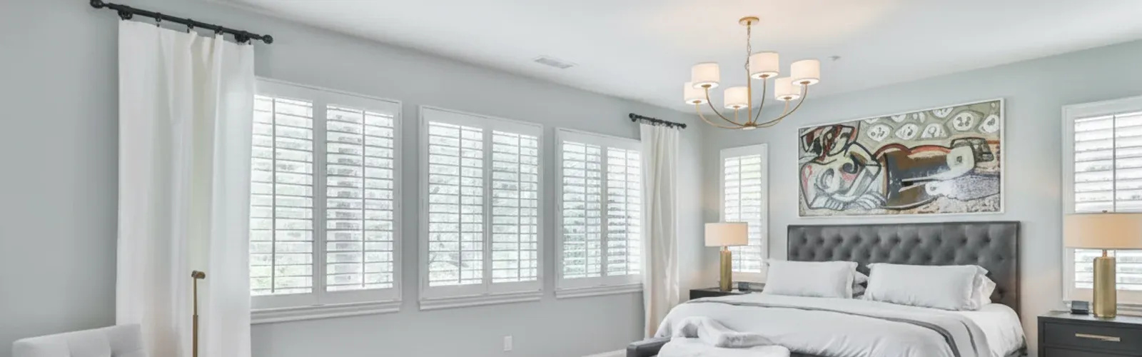 White plantation shutters in a bright residential bedroom