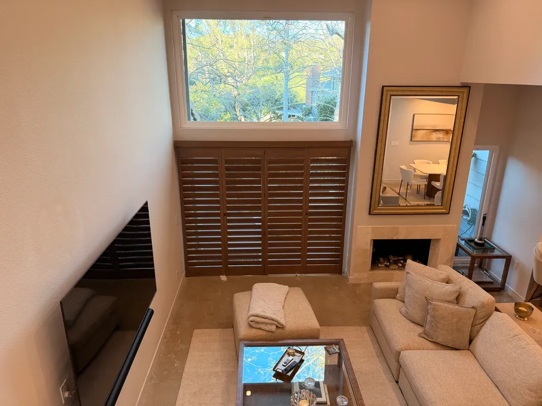 Stained wood shutters in a two-story living room
